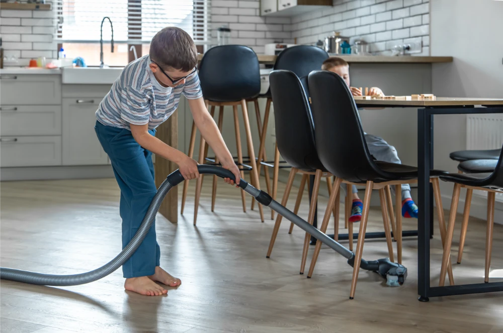 little-boy-with-glasses-cleans-house-with-vacuum-cleaner